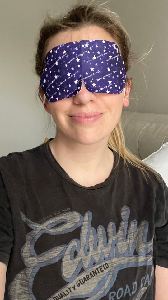 Woman wearing a purple star-patterned sleep mask.