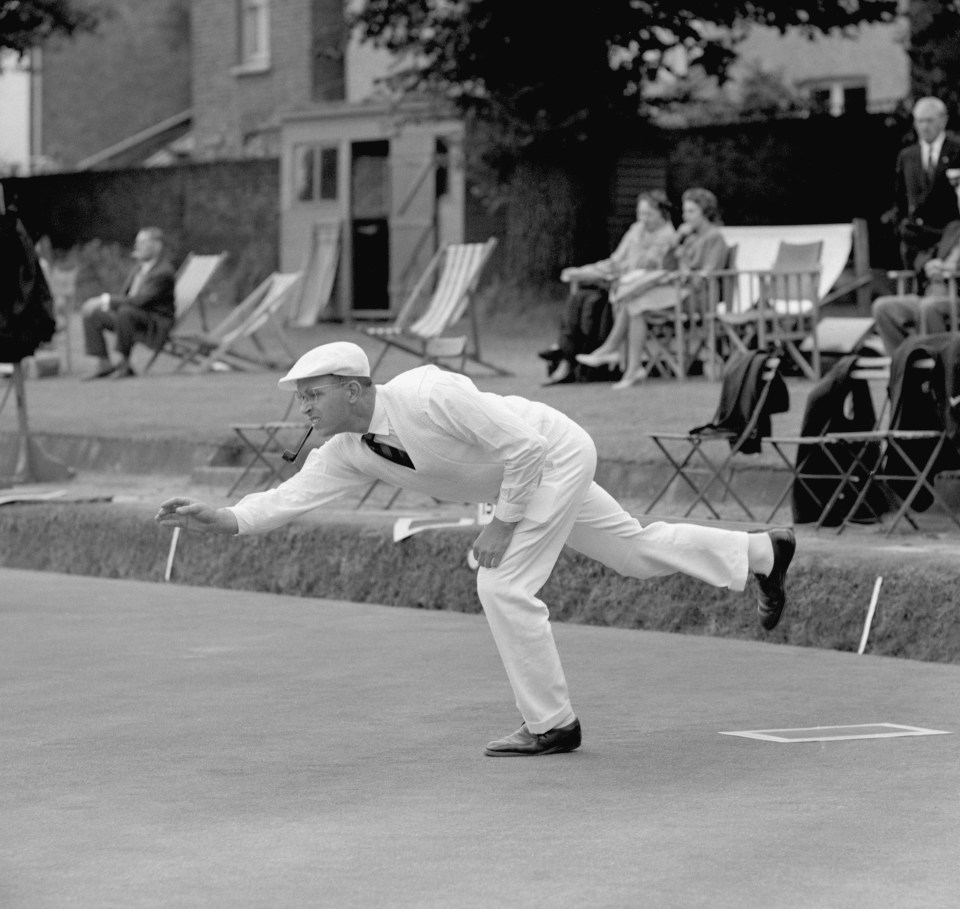 A man in white playing bowls.