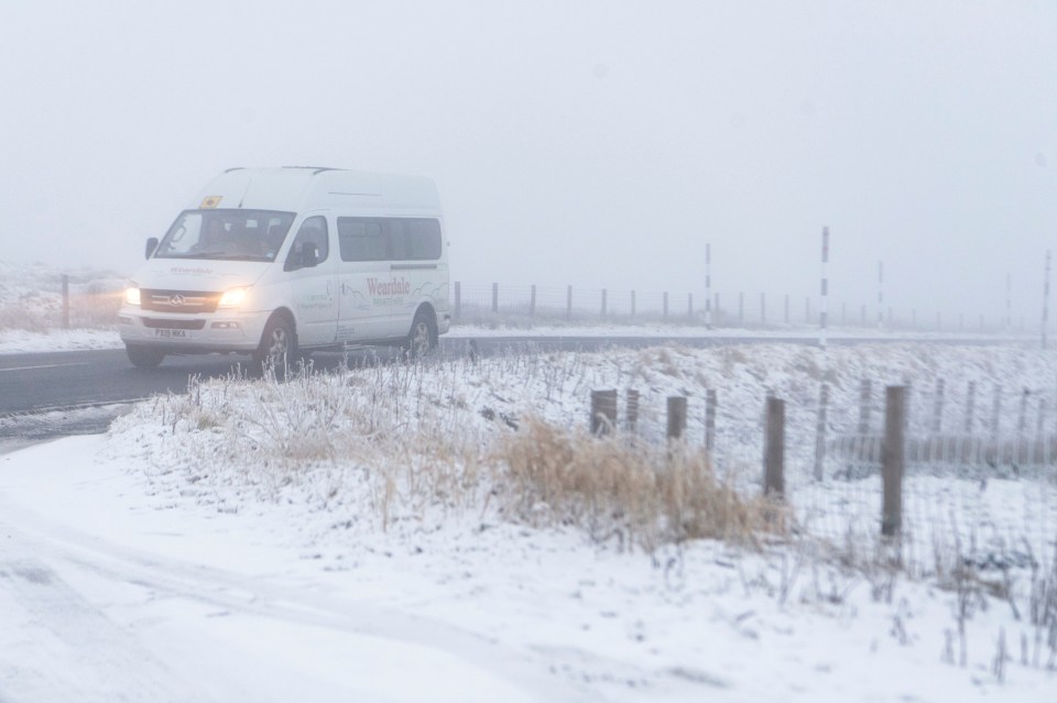 A van drives through a snow flurry in Killhope, County Durham this morning