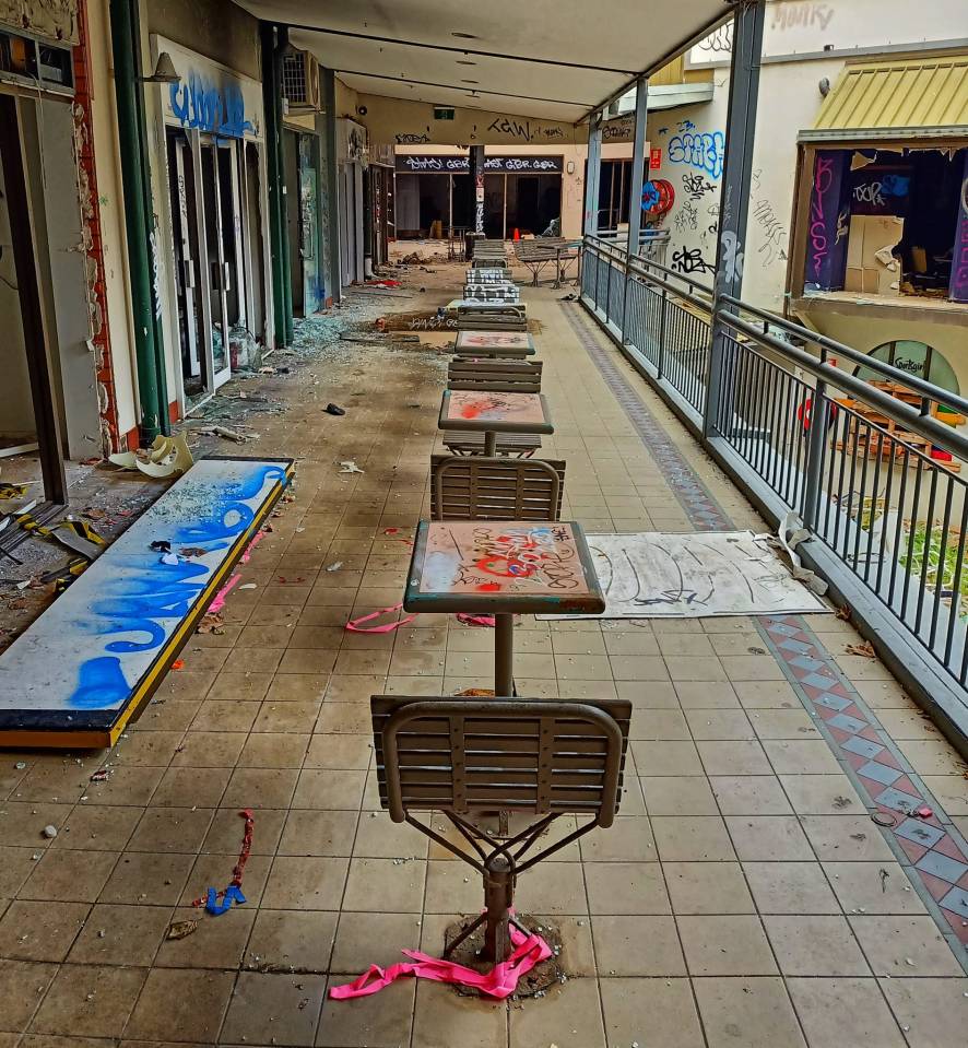 Graffiti and damaged tables and chairs are strewn everywhere