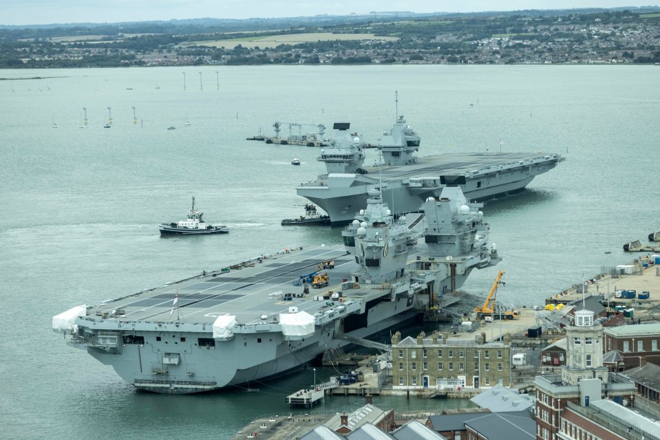 The Royal Navy aircraft carrier HMS Prince of Wales (L) sails next to the carrier HMS Queen Elizabeth