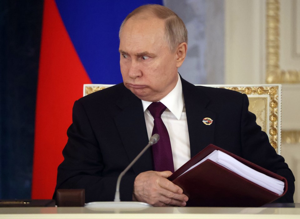 Russian President Vladimir Putin grimaces during a meeting with the Belarus president on Monday