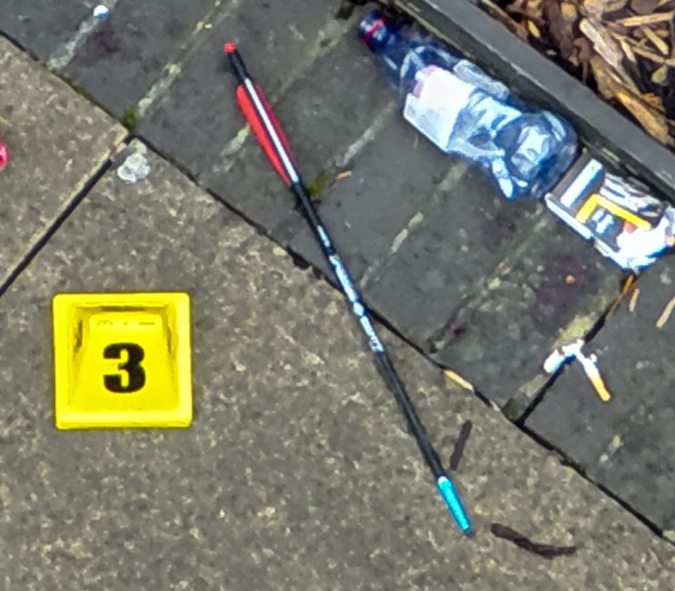 A crossbow arrow, water bottles and cigarette packs were found on the pavement outside the flats