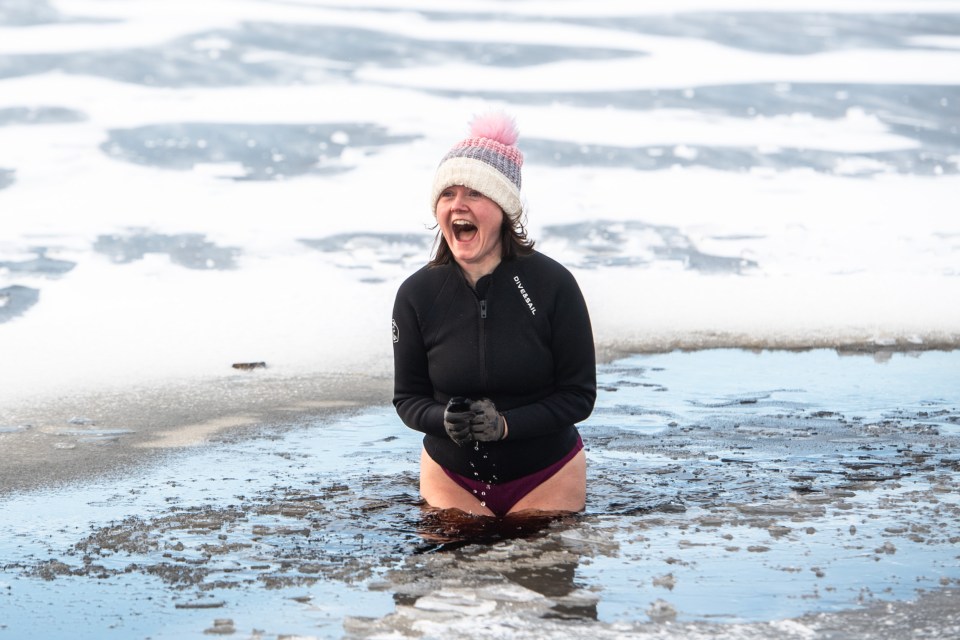 This woman braved a dip in a frozen lake in Huddersfield, West Yorkshire yesterday