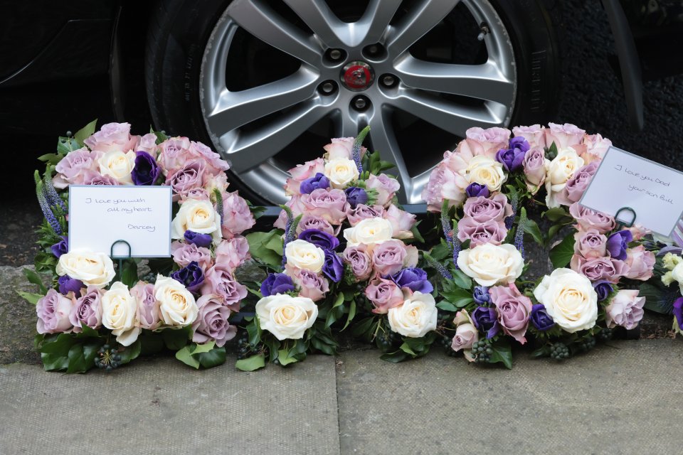 Pink, purple, and white flowers at the funeral spelt out 'Dad'