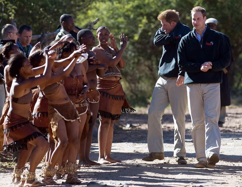 Harry and William are greeted by traditional dancers in Botswana in 2010