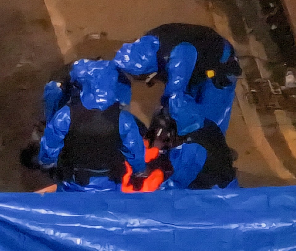 Officers covered the suspect in an orange jumpsuit