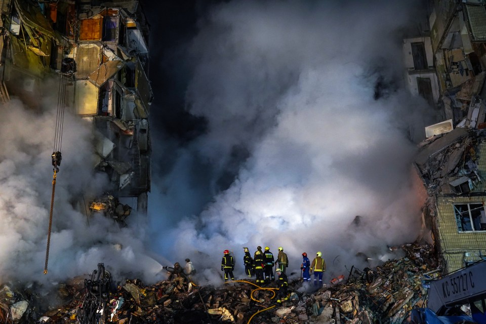 Firefighters search for survivors at a residential building hit by a missile in Dnipro, Ukraine