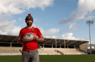 a man in a steeden jersey holds a rugby ball