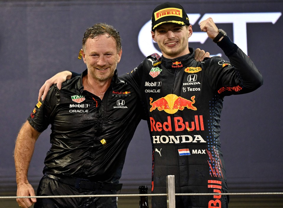 2021 FIA Formula One World Champion Red Bull's Dutch driver Max Verstappen celebrates with British Team Principal of the Red Bull Racing Formula One Christian Horner (L) on the podium of the Yas Marina Circuit after the Abu Dhabi Formula One Grand Prix on December 12, 2021. - Max Verstappen became the first Dutchman ever to win the Formula One world championship title when he won a dramatic season-ending Abu Dhabi Grand Prix at the Yas Marina circuit on December 12, 2021. The Red Bull driver won his 10th race of the season to finish ahead of seven-time champion Lewis Hamilton. (Photo by ANDREJ ISAKOVIC / AFP) (Photo by ANDREJ ISAKOVIC/AFP via Getty Images)