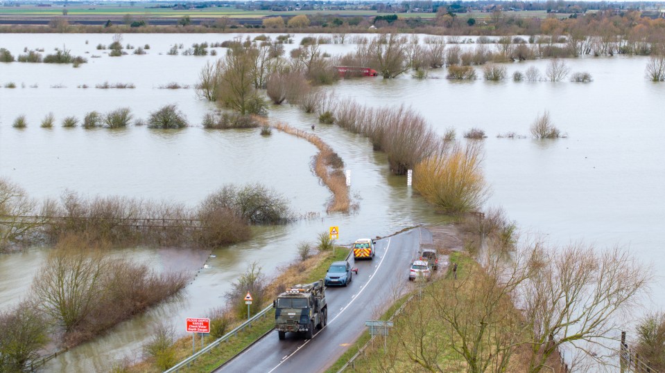 Recovery workers on the flooded A1101 in Norfolk yesterday