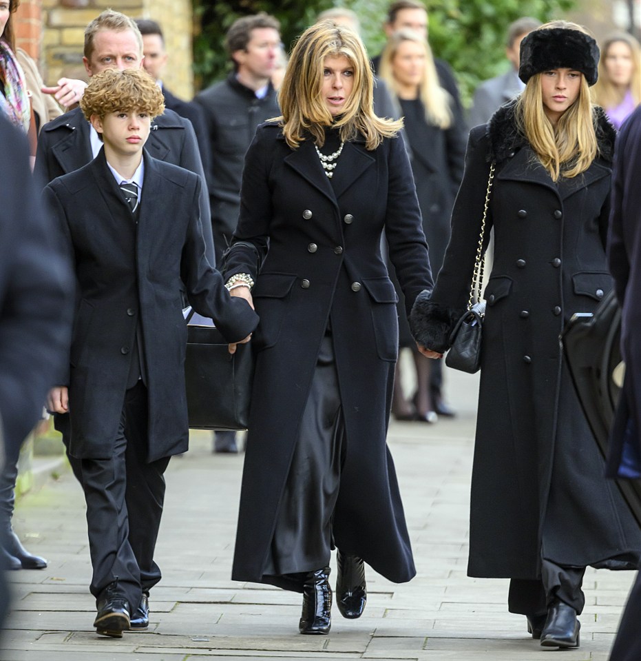 Kate at the funeral holding the hands of her children, Billy (left) and Darcey (right)