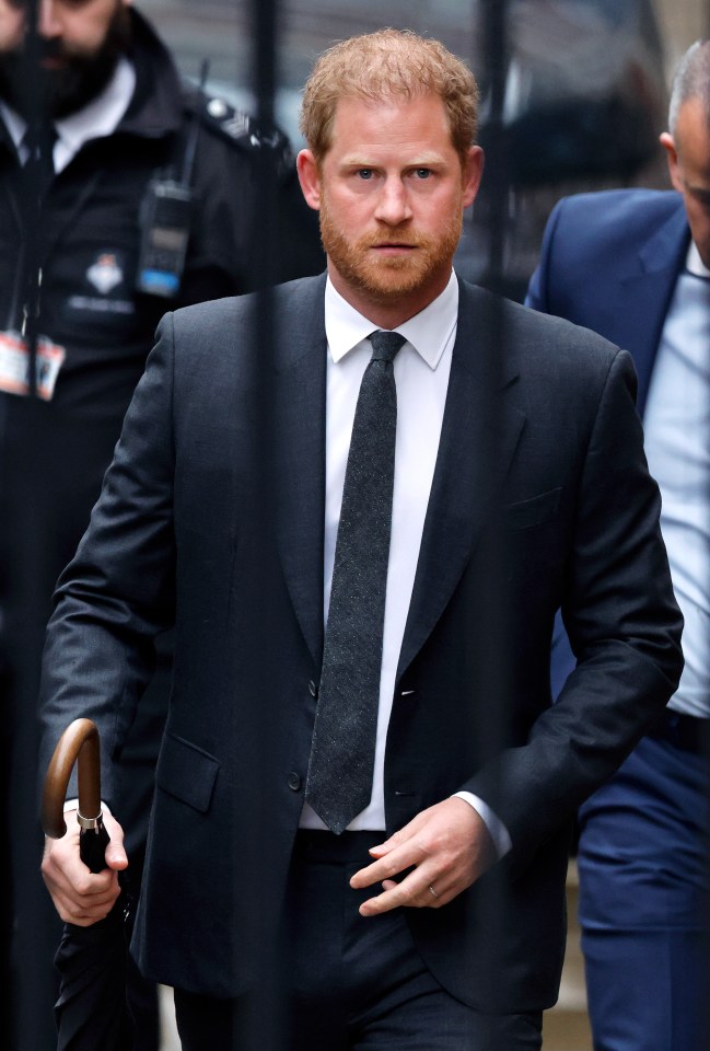 a man in a suit and tie is holding an umbrella