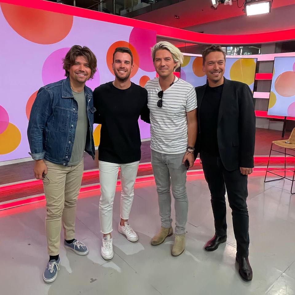 Jesse pictured with the band Hanson