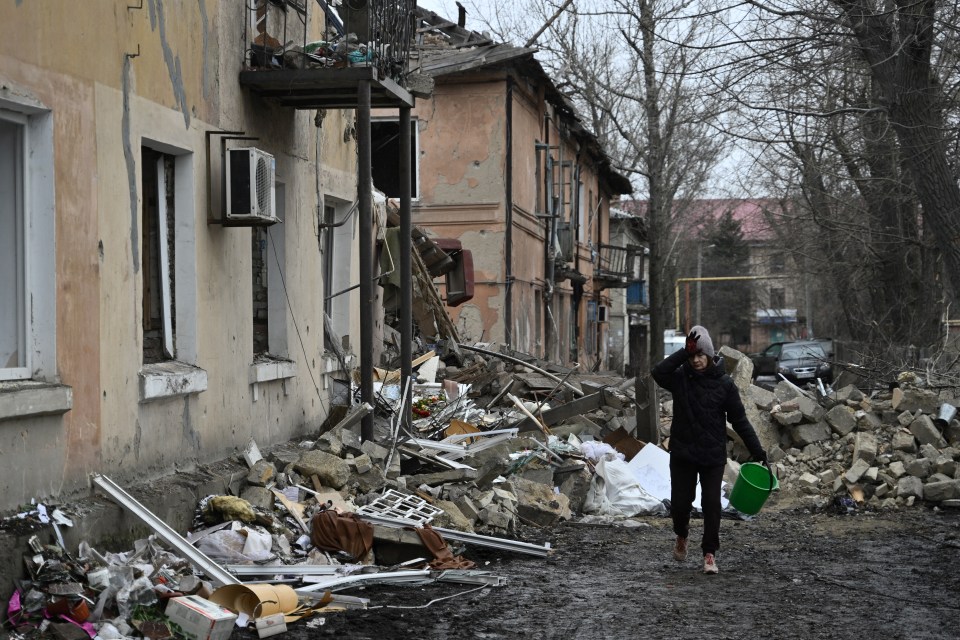 A woman walks past a residential building damaged by a missile attack in the town of Selydove, Donetsk region, on February 8, 2024, amid the Russian invasion of Ukraine. (Photo by Genya SAVILOV / AFP) (Photo by GENYA SAVILOV/AFP via Getty Images)