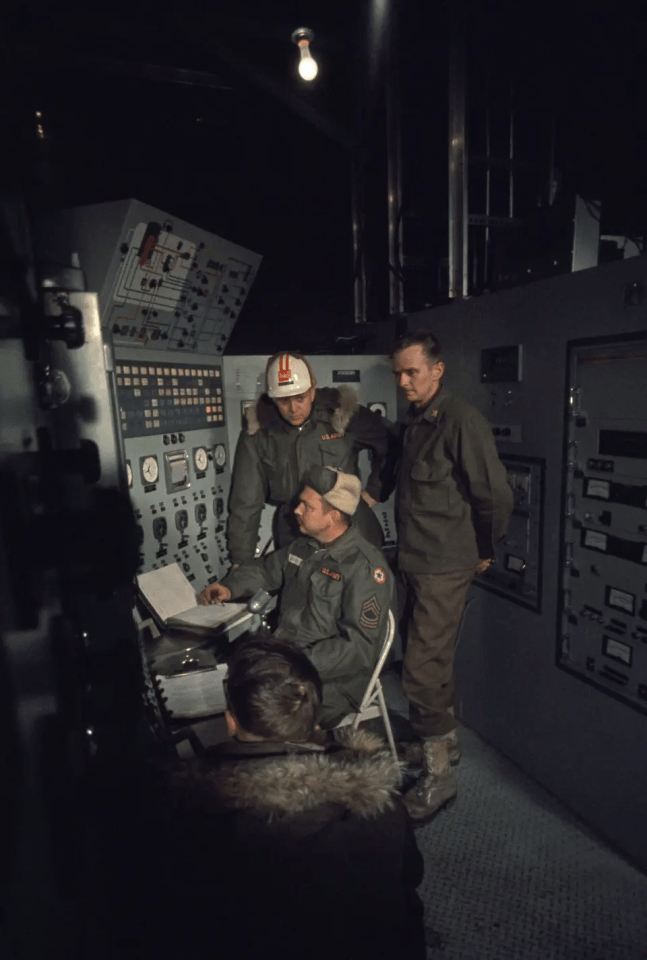 Anxious specialists watch a control panel at nuclear power plant, Camp Century, Greenland