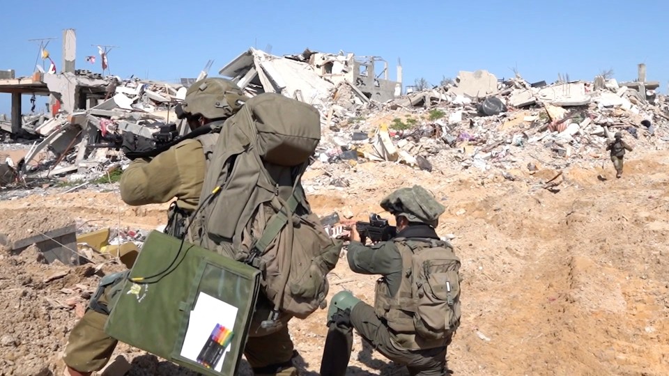 Israeli soldiers operate among the ruins of buildings in the Gaza Strip