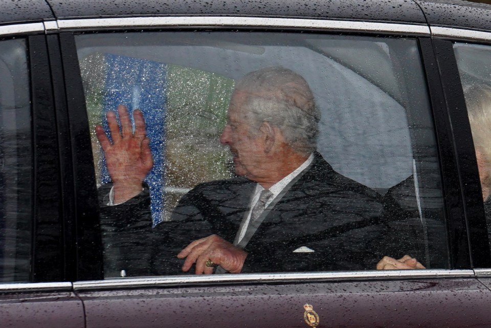 King Charles III waves to wellwishers as he and and Queen Camilla arrive back at Clarence House