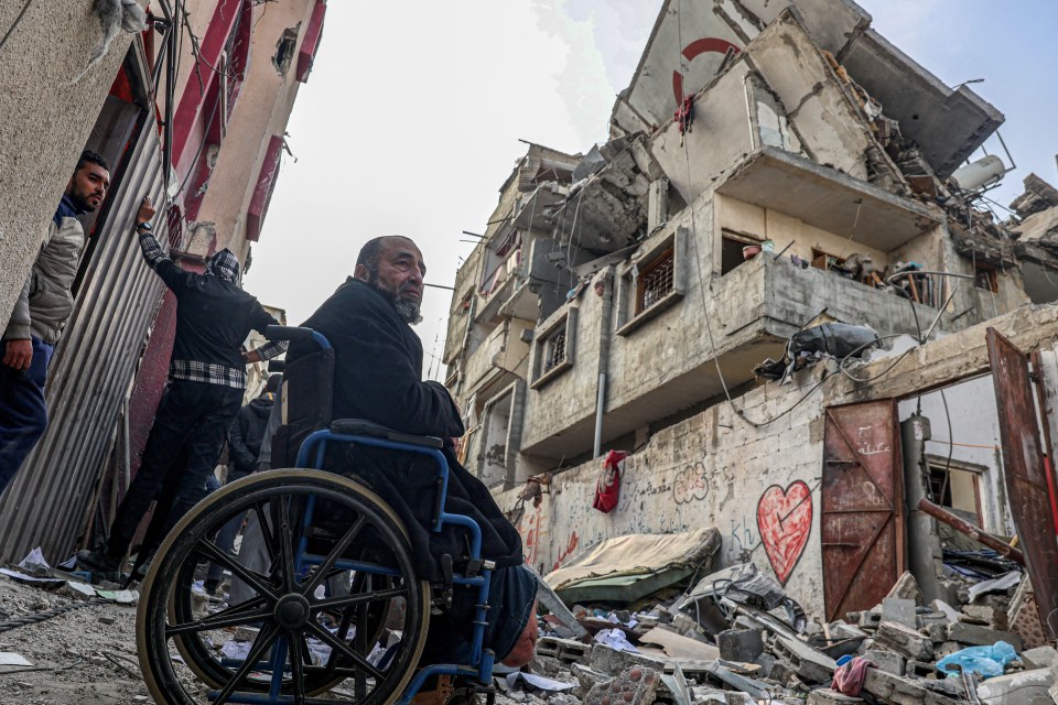 Palestinians look at the rubble of their house destroyed in an overnight Israeli airstrike in Rafah