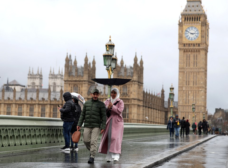 Londoners brave the wind and rain outside Parliament yesterday