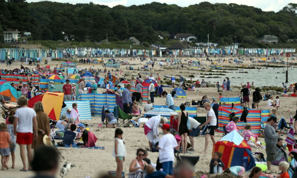 People enjoy the warm weather on Avon Beach in Dorset