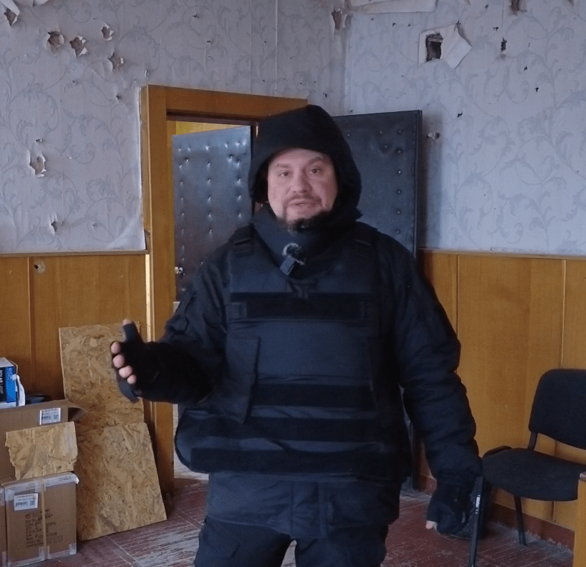 Sergey Panashchuk shows the walls of a local school covered in shrapnel holes