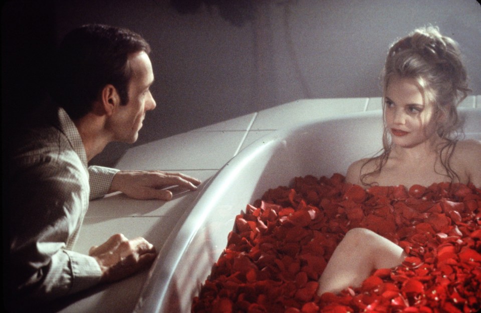 Mena Suvari lying nude on a bathtub of red rose petals