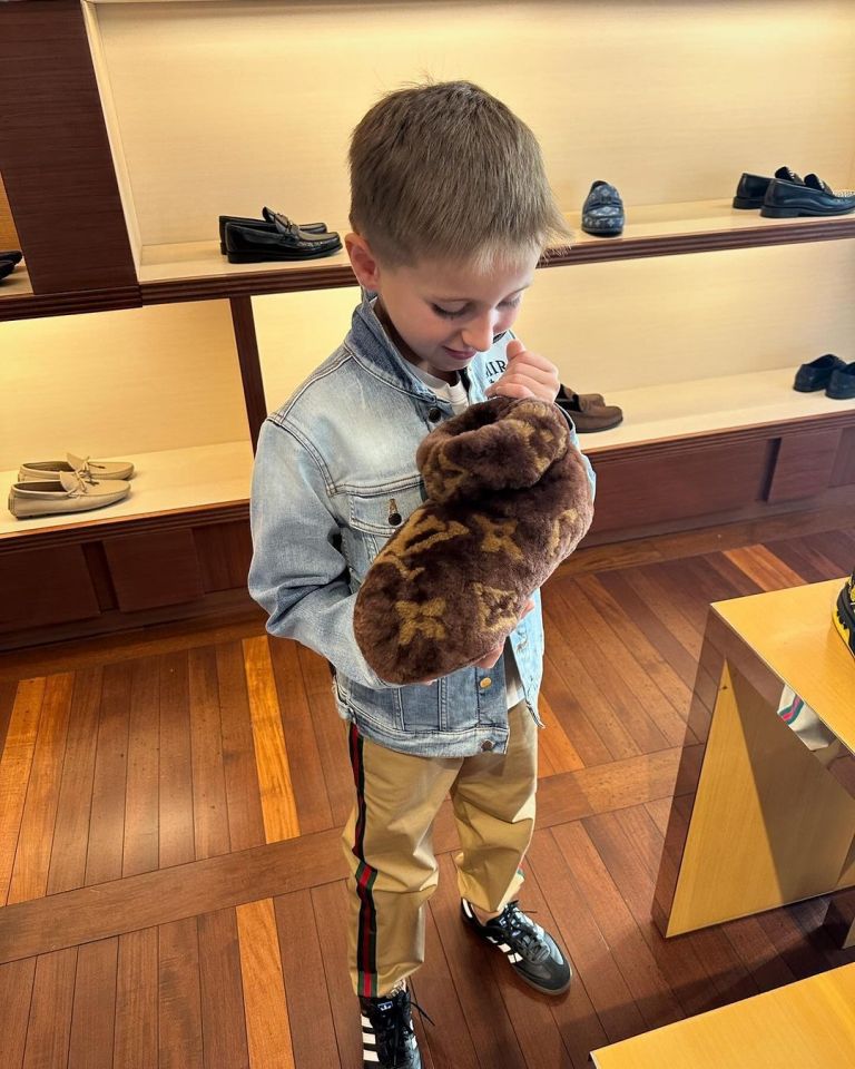 The little boy beamed after finding a pair of Louis Vuitton boots