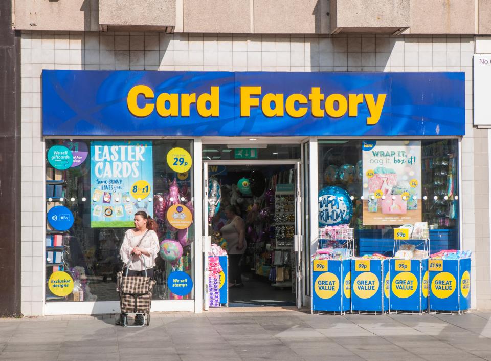 Card Factory shop exterior with a woman and shopping trolley.