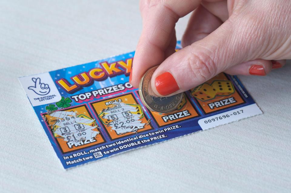 A Lucky Roll scratchcard being played with a coin