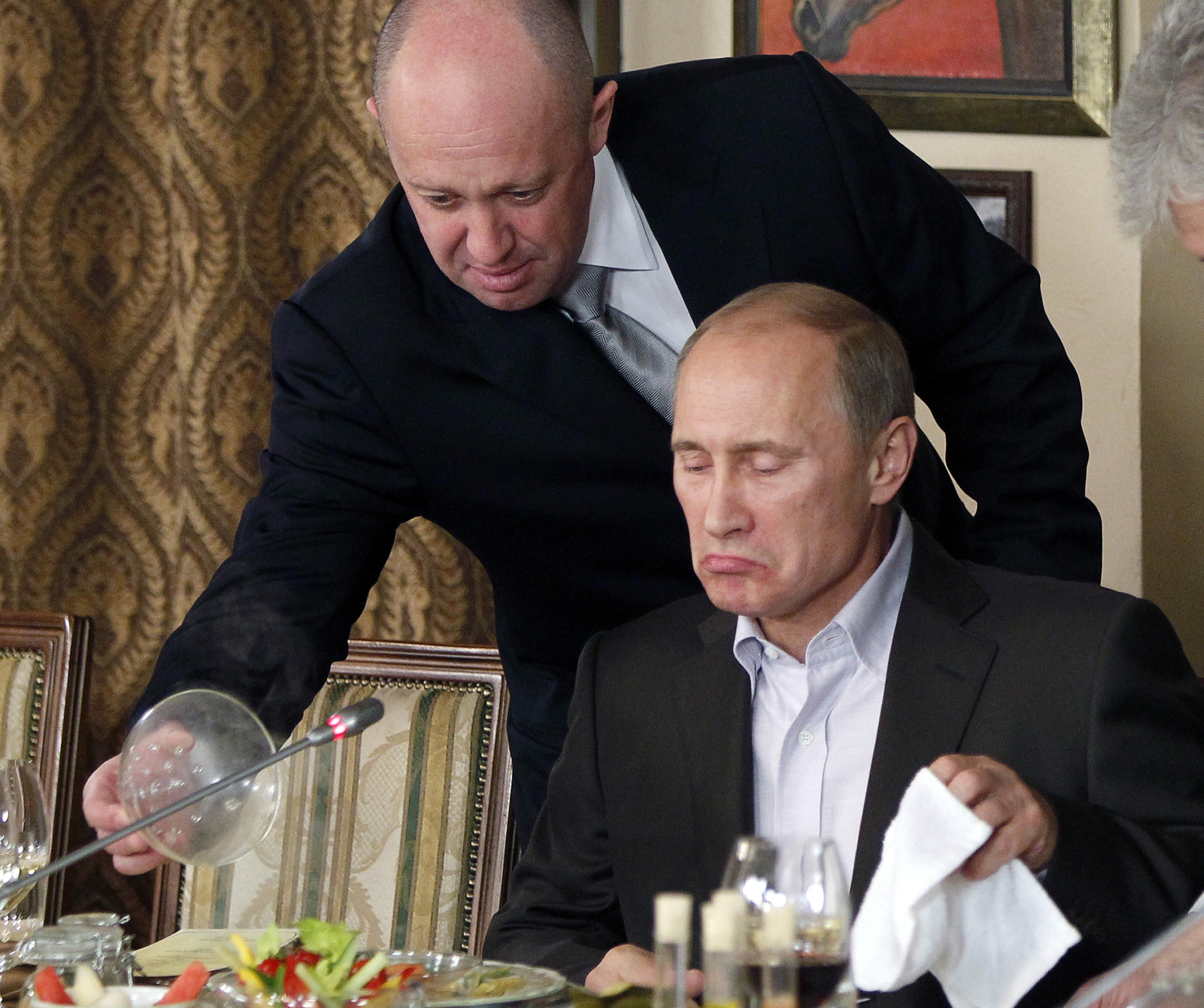 Yevgeny Prigozhin, top, serves food to then-Russian Prime Minister Vladimir Putin in Moscow in 2011