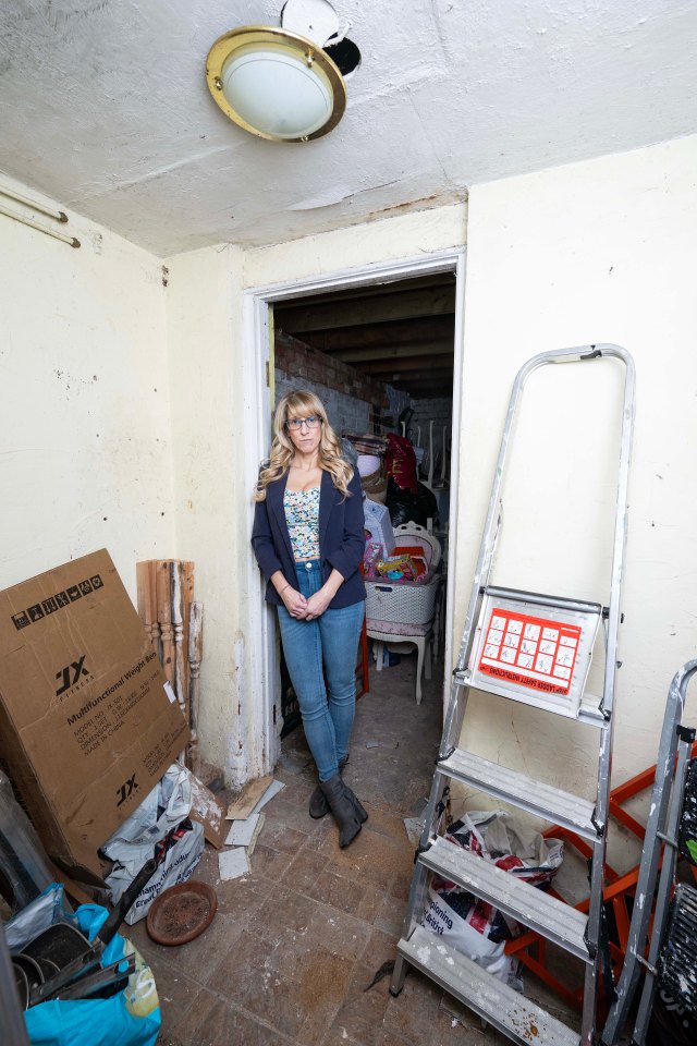 Claire inside her home, with a hole in the scruffy ceiling