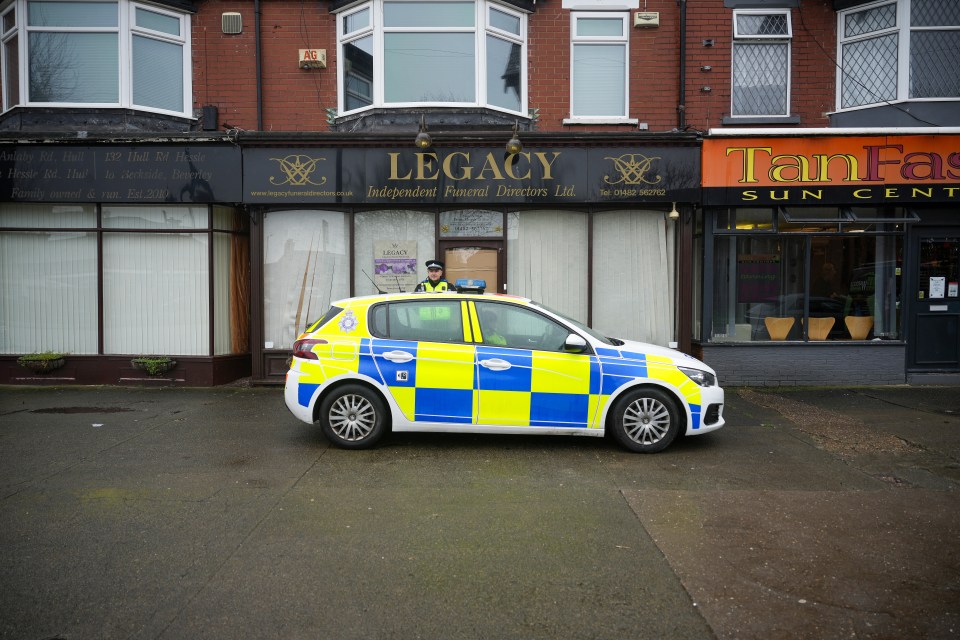 Police guard the funeral parlour after the raid