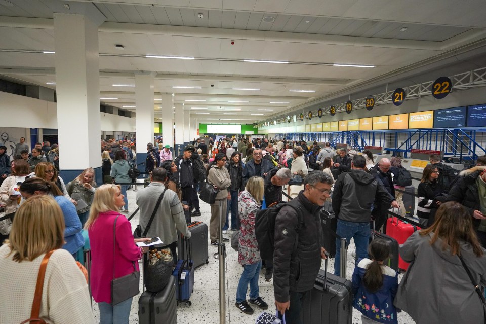 Holidaymakers queue for check in at Manchester Airport's Terminal One