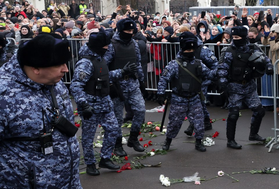 Riot police crushing over flowers brought in honour of Navalny