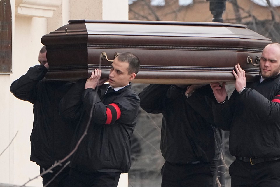 Workers carry the coffin of Navalny to the church