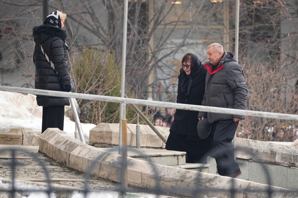 Navalny's parents Anatoly, right, and Lyudmila walk up to the church