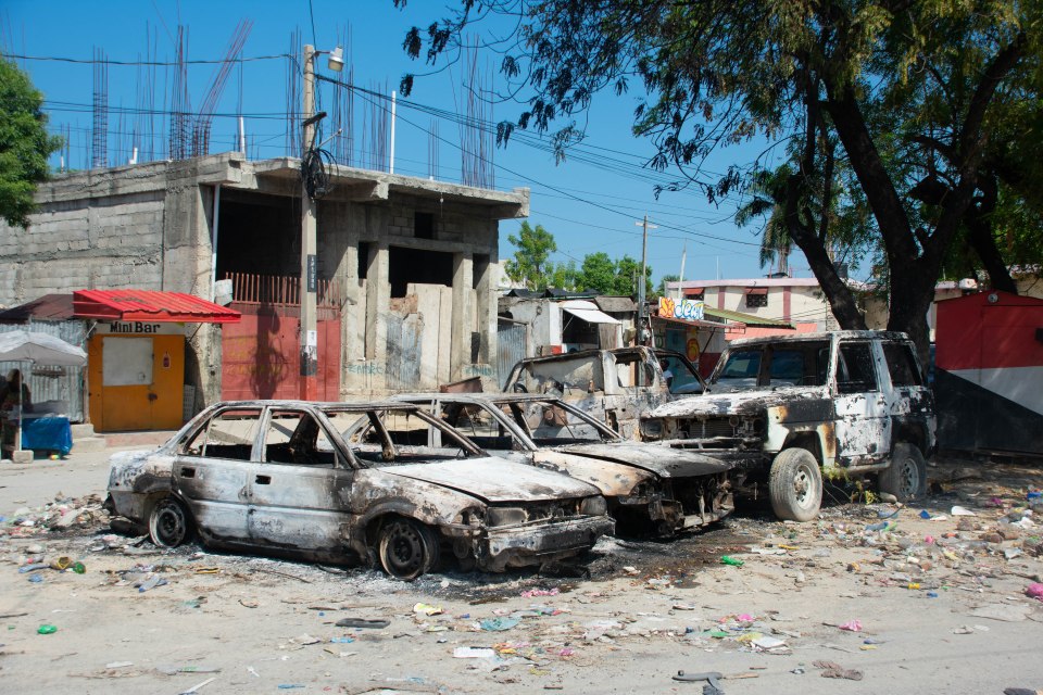 Charred vehicles remain parked as gang violence escalates in Port-au-Prince