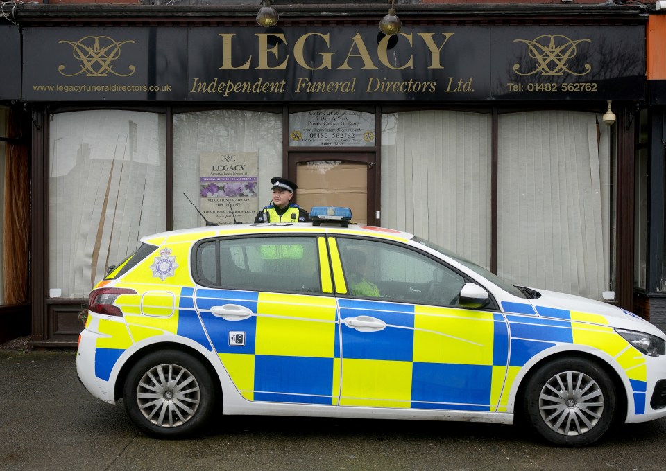 Police car parked outside Legacy Independent Funeral Directors.