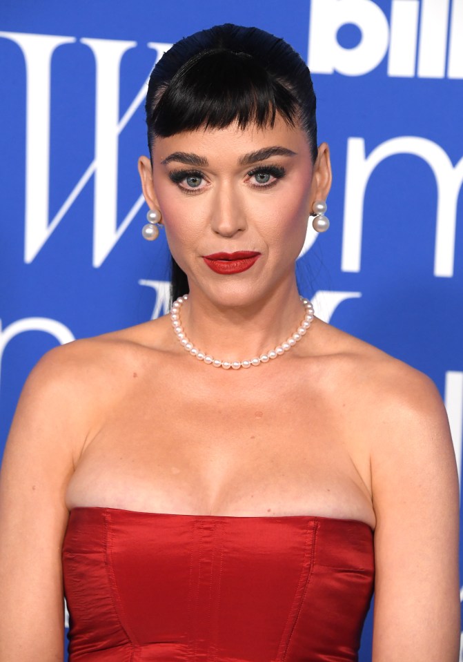 Katy wore a pearl choker and silver earrings to complement her look