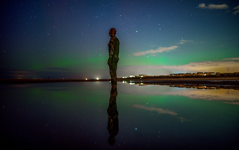 Northern Lights seen over one of the iron men statues at Anthony Gormley's Another Place, on Crosby Beach, Merseyside last night