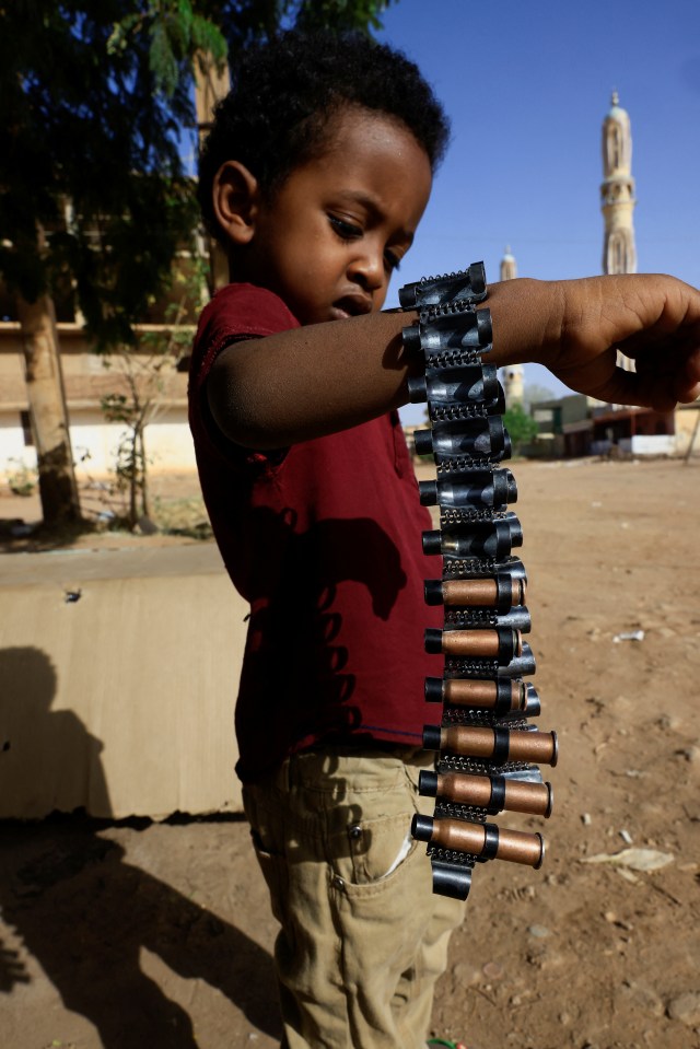 A young boy holds bullet cartridges as clashes between the RSF and Sudan’s army continue in Khartoum North