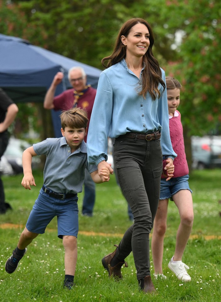 Kate - pictured here with Princess Charlotte and Prince Louis in May -  also spent Sunday morning watching her three children take part in sports