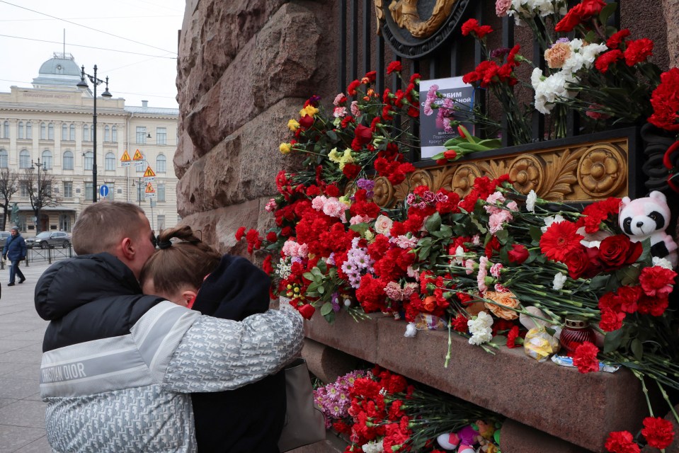 A man and woman attend the site of makeshift memorial