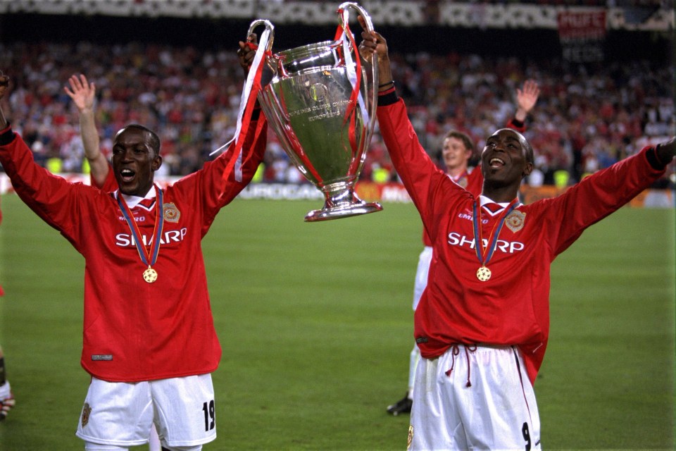 Dwight Yorke and Andy Cole celebrating with the Champions League trophy in 1999