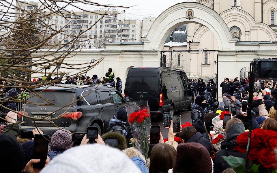 A hearse transporting the coffin arrives at the funeral service