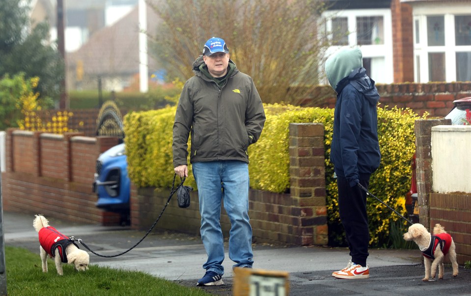 He emerged to walk the dogs and was pictured deep in conversation with an unidentified woman