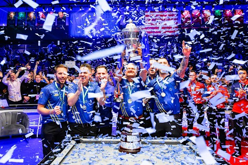 a group of men holding a trophy with confetti falling around them