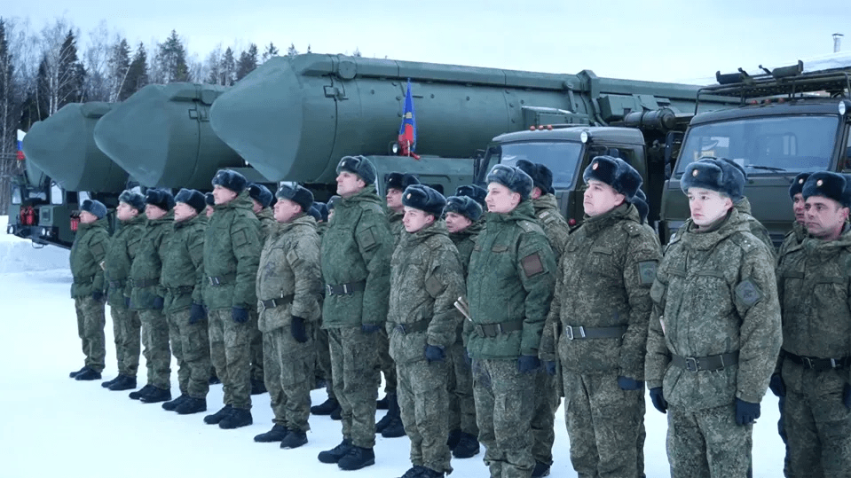 Russian troops stand with Yars mobile nuclear missile launchers