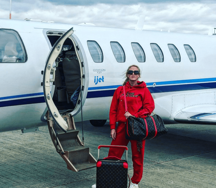 To match her red tracksuit, Paris donned a Louis Vuitton suitcase and holdall